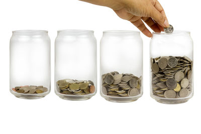 Close-up of hand holding jar against white background
