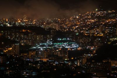 Illuminated cityscape against sky at night