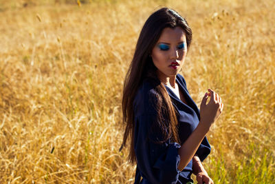 Beautiful young woman with make-up while standing on field