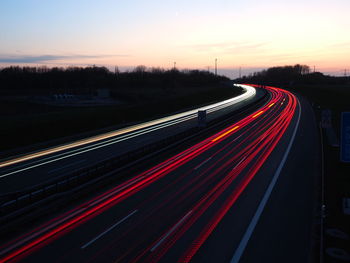 High angle view of light trails on road at sunset