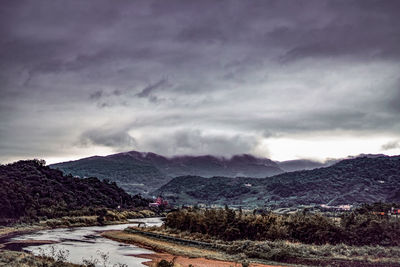 Scenic view of mountains against cloudy sky
