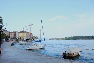 Sailboats moored on sea against sky