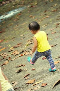 Rear view of boy playing on land