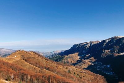 Scenic view of mountains against clear blue sky