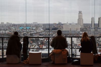 Rear view of people looking at cityscape against sky