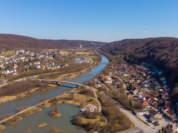 High angle view of city by mountain against sky