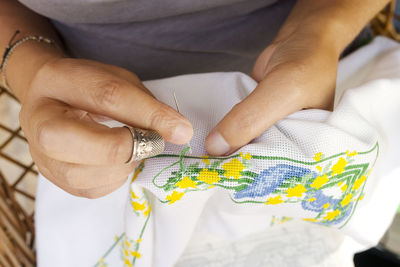 Midsection of woman embroidering on fabric