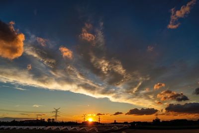 Silhouette landscape against dramatic sky during sunset