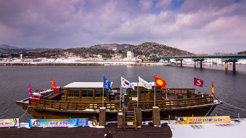 Boats moored on shore against sky