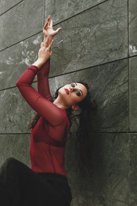 Portrait of young woman with arms raised on floor