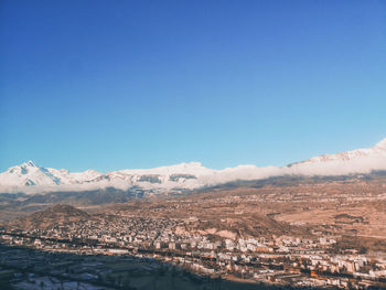 Scenic view of snowcapped mountains against clear blue sky