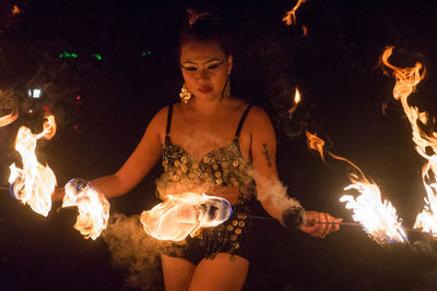 Young woman performing with fire at night