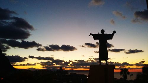 Silhouette statue against sky during sunset