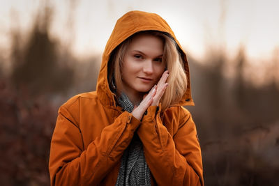 Portrait of young woman standing against plants