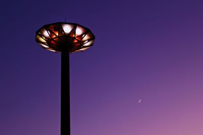 Low angle view of illuminated street light against blue sky