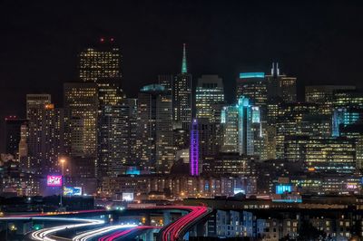 Low angle view of illuminated cityscape against sky at night