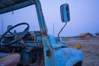 Abandoned car against blue sky