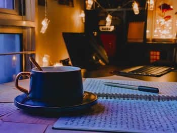 Close-up of coffee cup on table during writing process.