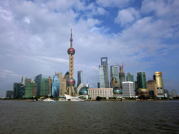 View of cityscape against cloudy sky