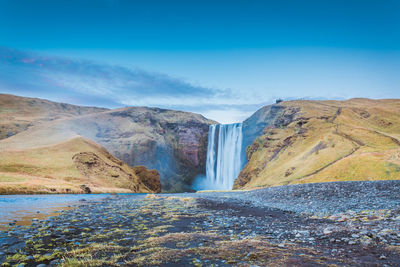Scenic view of waterfall against sky
