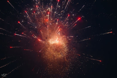 Low angle view of firework display at night