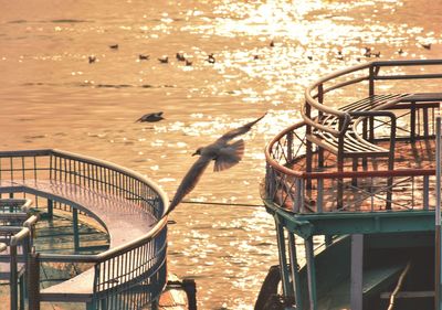 Reflection of railing on ganges against sky during sunset