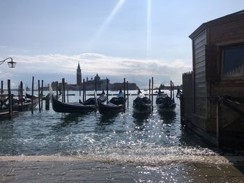 Boats moored in canal against sky