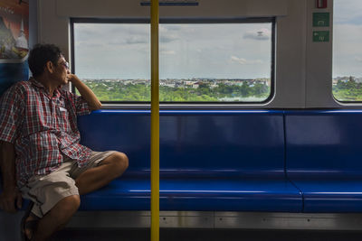 Man looking through train window