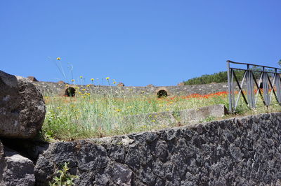View of rocks against clear blue sky