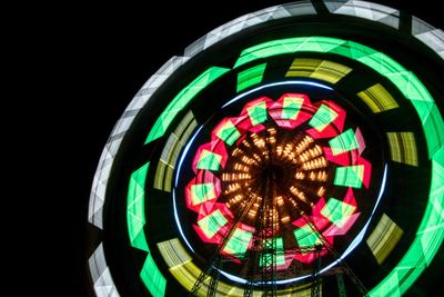 Low angle view of illuminated ferris wheel against sky at night