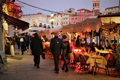 People walking on street in city at dusk 