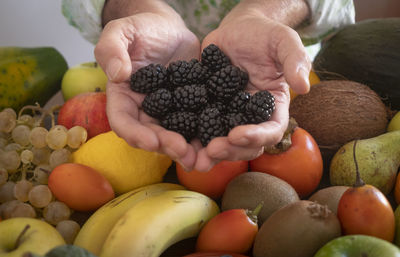 Midsection of man holding fruits