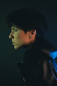 Portrait of young man against black background