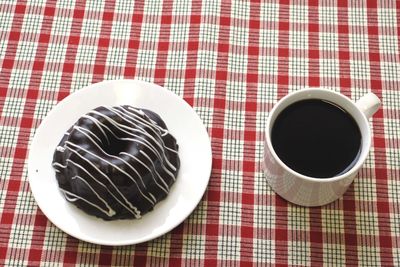 High angle view of fresh bundt cake served with black coffee on table