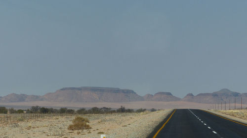 Empty road along countryside landscape