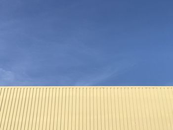 Low angle view of wall against blue sky