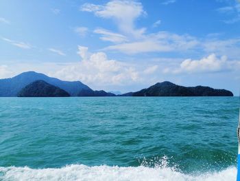 Scenic view of sea and mountains against blue sky