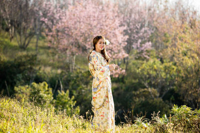 Woman standing by flowers