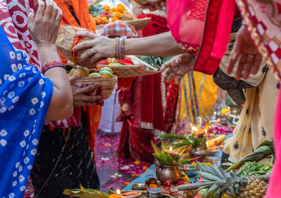 Indian devotee worshiping hindu almighty sun god with holy offerings at chhath festival