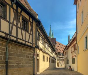 Street amidst buildings in town against sky