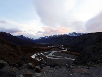 Scenic view of road by mountains against sky