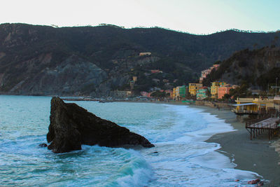 Scenic view of sea and mountains against clear sky