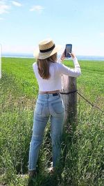 Full length of woman using phone while standing on land