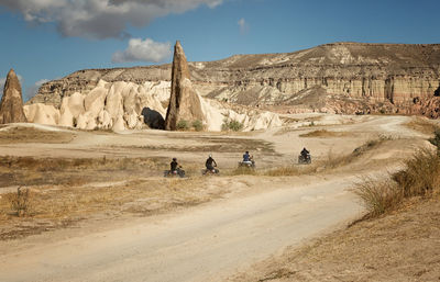 Men riding quadbike at desert