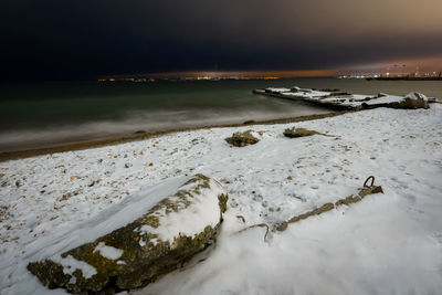 Scenic view of sea against sky at night during winter