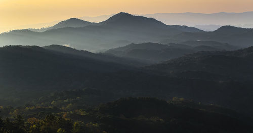 Scenic view of silhouette mountains against sky during sunset