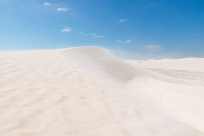 Sand dunes in desert against sky