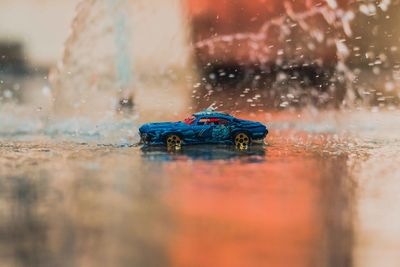 Toy car moving on puddle during rainy season