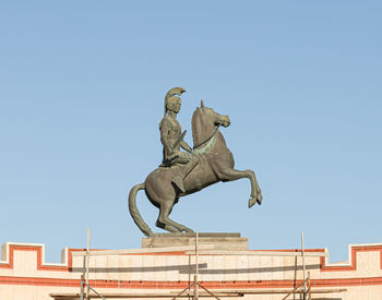 Low angle view of statue against clear blue sky