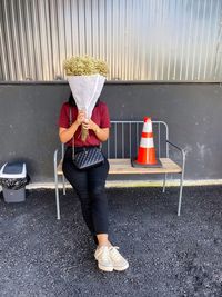 Full length portrait of woman standing on bench